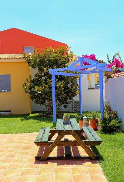 Quintal com banco de madeira e quiosque azul — Fotografia de Stock