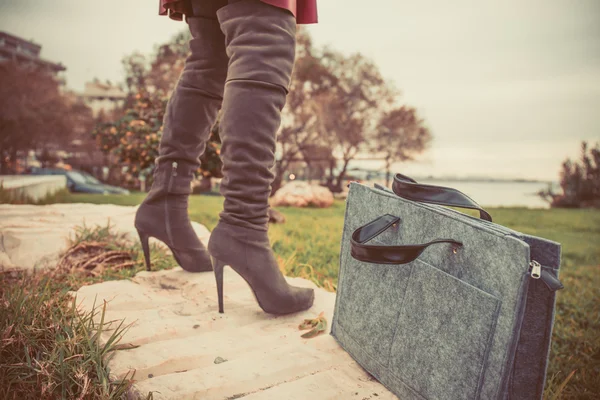 Benen van de vrouw het dragen van laarzen en handzak — Stockfoto