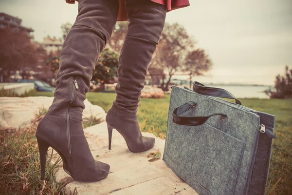 Benen van de vrouw het dragen van laarzen en handzak — Stockfoto