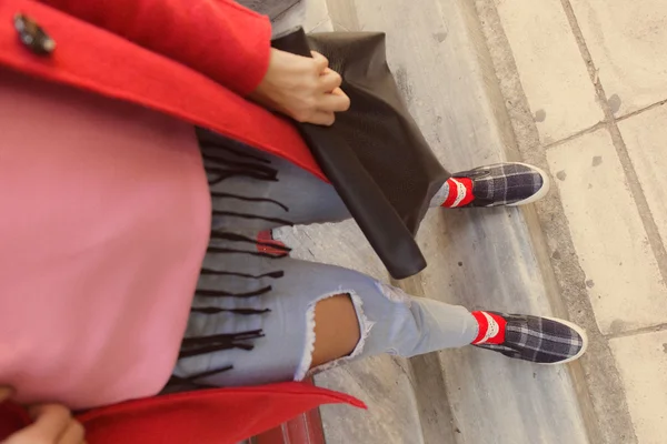 Piernas de mujer con zapatos deportivos y bolso de mano — Foto de Stock