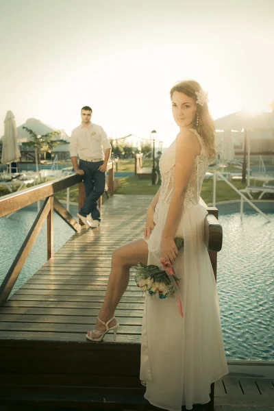 Mariée et marié posant sur un pont — Photo