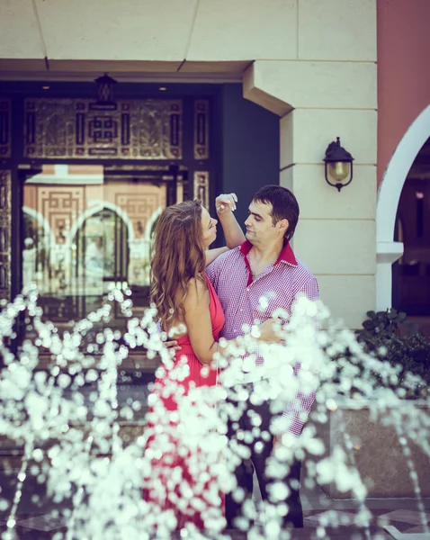 Enamored couple posing behind the fountain — Stock Photo, Image