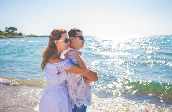 Szerelmes pár pózol a tengerparton — Stock Fotó