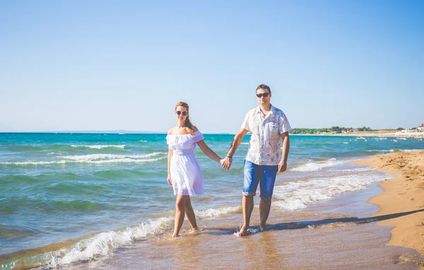 Förälskad par poserar på en strand — Stockfoto