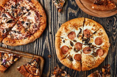 Tahta arka planda pizza dilimleri. Tahta masadaki İtalyan pizzası.