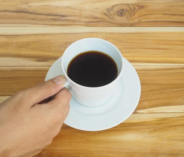 Рука, держащая белую чашку кофе — стоковое фото