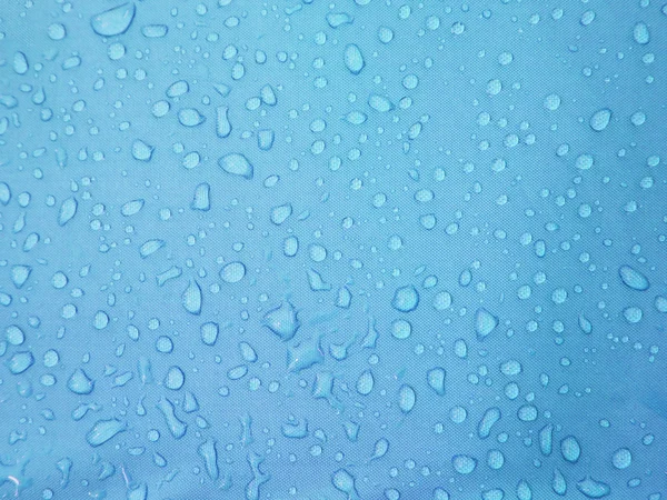 Σταγόνες νερού σε μπλε αδιάβροχο ύφασμα — Φωτογραφία Αρχείου