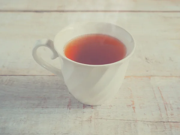 White vintage cup of tea on wooden table