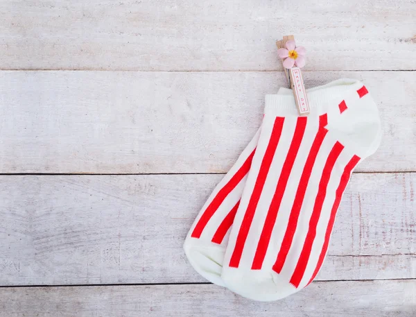 Calcetines blancos con rayas rojas y clavija de ropa de madera —  Fotos de Stock