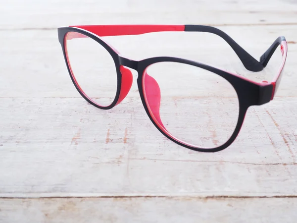 Óculos de olho preto e vermelho no fundo de madeira — Fotografia de Stock