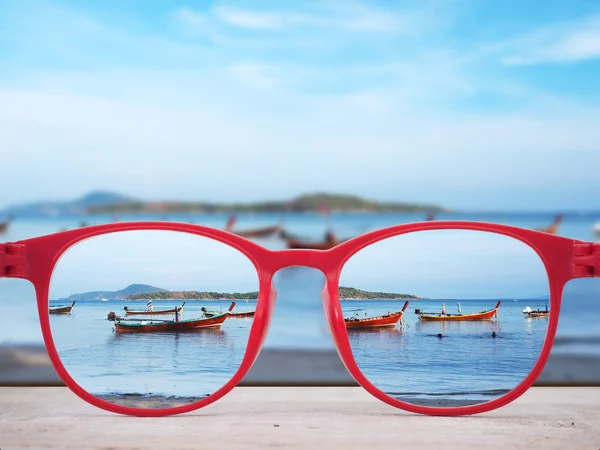 Praia de verão focada em lentes de óculos vermelhos — Fotografia de Stock