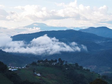 Akşamları Mon Jam, Chiang Mai, Tayland 'da tatil köyü ve tarlası olan bir dağ manzarası.