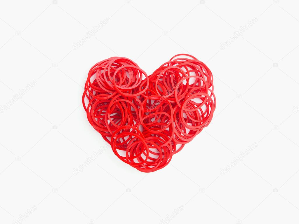 Close up heap red rubber bands in heart shape on white backgroud. Love concept.