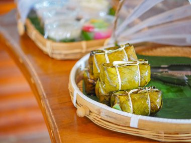 Buharda pişirilmiş pirinç yığınını içinde muz (Kao tom çamuru) ve bambu tepsisine sarılmış muz yaprağı ile kapatın. Geleneksel Tayland ev yapımı tatlı.