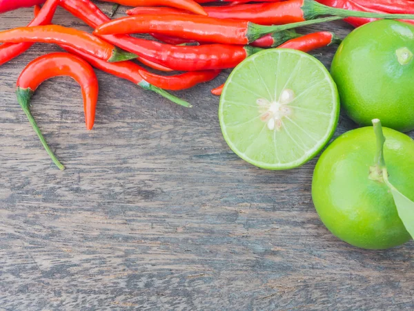 Chili y lima sobre mesa de madera — Foto de Stock