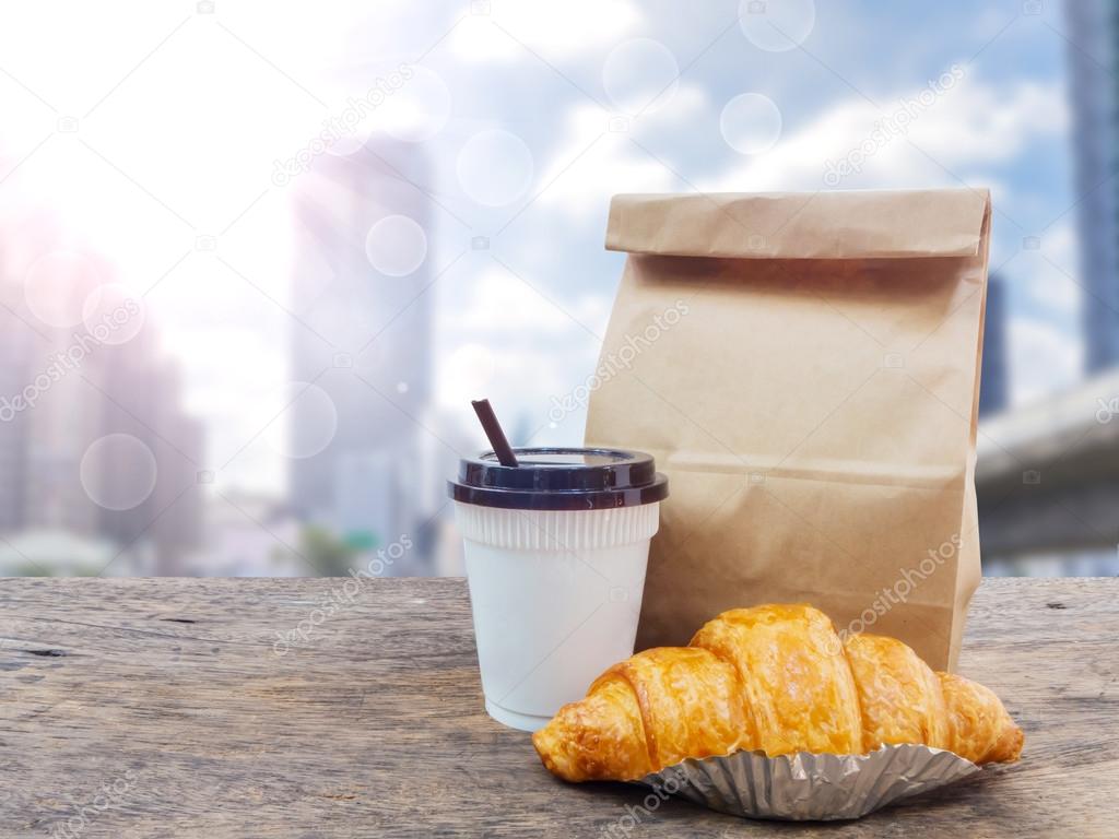 coffee and croissant with paper bag for breakfast