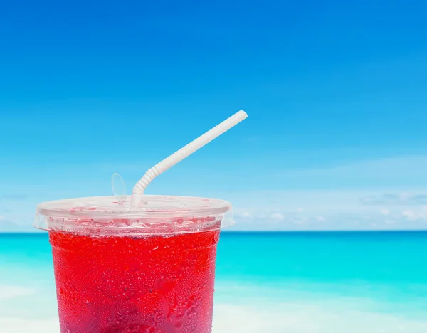 Suco de frutas no fundo da praia desfocada — Fotografia de Stock