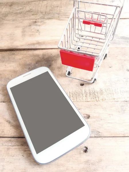 Mobiele telefoon en kleine winkelwagen — Stockfoto
