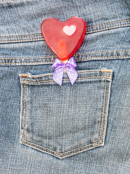 Rött hjärta form med rosett i denim pocket — Stockfoto