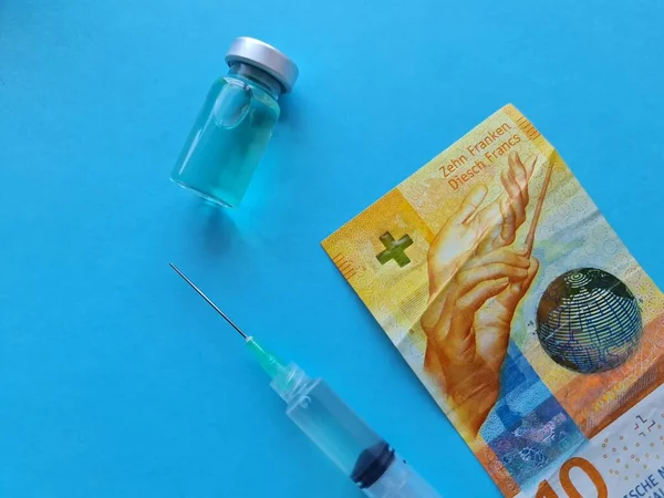 Banconota Svizzera Dieci Franchi Flacone Medicinali Siringa Sullo Sfondo Blu — Foto Stock