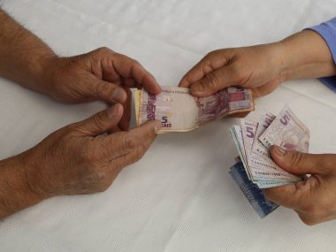 Farklı mezheplerden Brezilya banknotları alan ve ödeyen eller