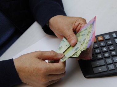 Şili banknotlarını sayan yaşlı bir kadının elleri