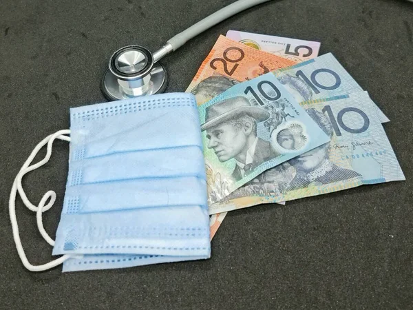 australian banknotes, disposable face mask and stethoscope on the black background