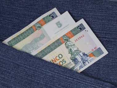 Mavi kot kumaş arasında beş pezoluk Küba banknotları