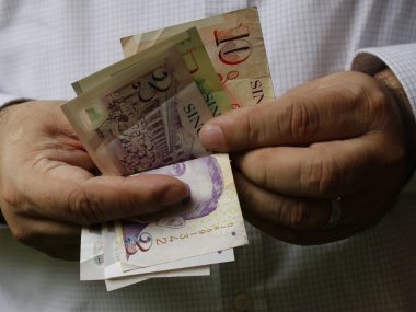 El ele tutuşan ve sayan tek bir adamın paraları.