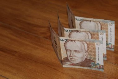 Ahşap yüzeyde 20 tabanlı Peru banknotları
