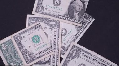 Folded US dollar bills falling on a black background