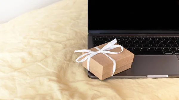 The gift box banner is on the laptop keyboard. The concept of online gifts. . High quality photo