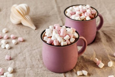 Bir Noel oyuncağıyla keten bir masa örtüsünün üzerinde fincanlarda lokum bulunan sıcak çikolata. Yüksek kalite fotoğraf