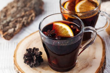 Portakallı ve yıldız anasonlu bardaklarda ahşap bir stantta sıcak şarap. Yüksek kalite fotoğraf