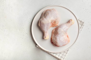 Çiftlik tavukları. Tabakta soğuk çiğ tavuk bacağı. Boşluğu kopyala.