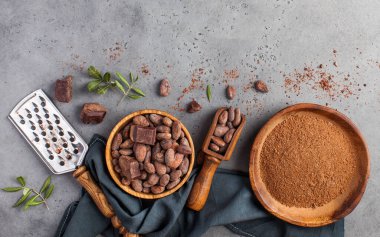 Kakao çekirdeği, kakao tozu, gri arka planda çiğ çikolata. Sağlıklı beslenme kavramı. Boşluğu kopyala.