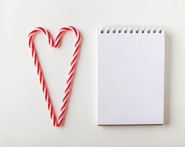 İki kırmızı ve beyaz lolipop bir kalp şeklinde katlanır. Minimalizm. Noel kartı, Sevgililer Günü. Yüksek kalite fotoğraf