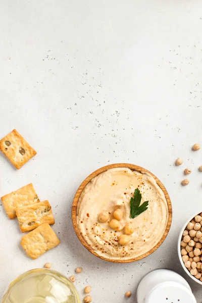 Hummus flatlay in un piatto di legno, ceci, crostini. Piatti di ceci, un piatto vegetariano. Copia spazio. — Foto Stock