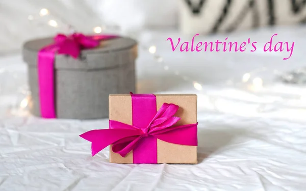 Confezioni regalo con nastro rosa sul letto. Concetto di San Valentino, 8 marzo, regalo di compleanno, altre festività. Copia spazio — Foto Stock