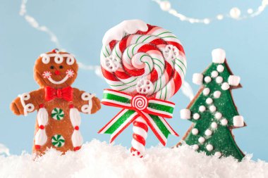 Noel lolipopu, Noel ağacı, mavi arka planda kardaki kızıl adam. Mutlu yıllar. Noel arkaplanı. 