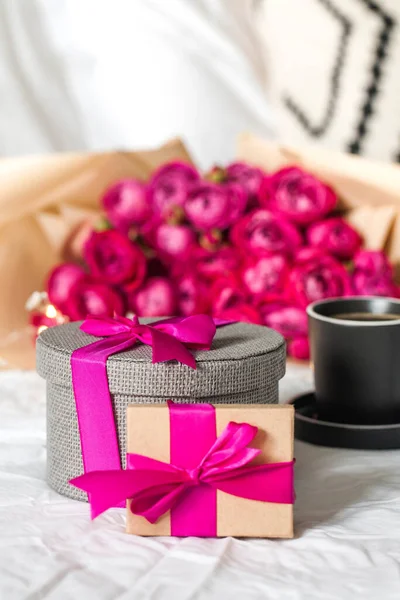 Coffrets cadeaux et bouquet de fleurs sur le lit. Concept de Saint Valentin, 8 mars, cadeau d'anniversaire et autres jours fériés. — Photo