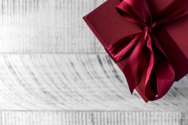 Tahta arka planda düz kırmızı hediye kutusu. Boşluğu kopyala.