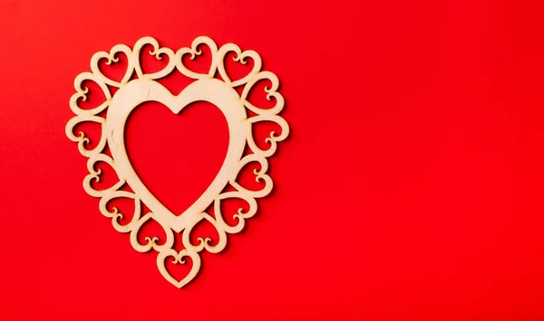 Corazón de madera plano sobre fondo rojo. Fondo del Día de San Valentín. Copiar espacio —  Fotos de Stock