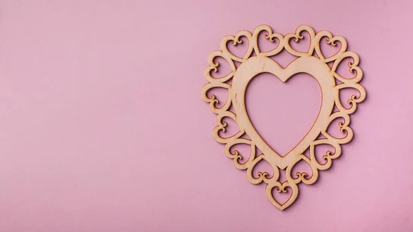 Corazón de madera plano sobre un fondo rosa. Fondo del Día de San Valentín. Copiar espacio —  Fotos de Stock