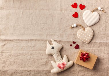 Düz kalp ve keten bir masa örtüsü üzerinde bir hediye kutusu. Sevgililer Günü geçmişi. Boşluğu kopyala.