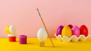 Paskalya yumurtası boyama konsepti. Parlak Paskalya yumurtaları, boya kutuları ve boya fırçası. Mutlu Paskalyalar.