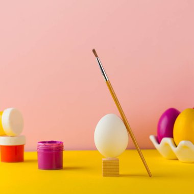 Paskalya yumurtası boyama konsepti. Parlak Paskalya yumurtaları, boya kutuları ve boya fırçası. Mutlu Paskalyalar.