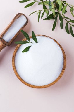 Pembe arka planda tahta bir kasede doğal tatlandırıcı. Şekerin yerine. Eritritol!. 