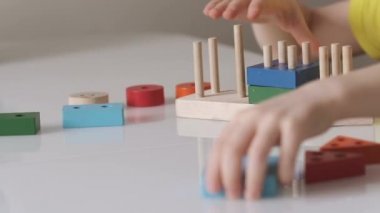 Bir çocuk mantıklı tahta bir oyuncakla oynuyor. Eğitici oyuncaklar. Video