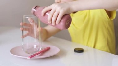 Çocuk bardağa meyve suyu dolduruyor ve pipet sokuyor. Video.